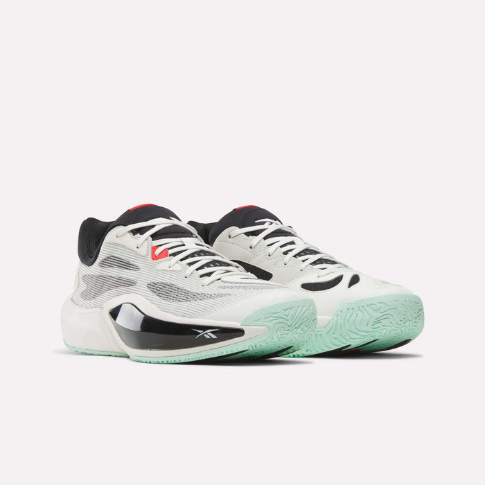 The Reebok Engine A 26 Basketball Shoes feature a white and black mesh upper, light green soles, and red accents for outstanding stability and energy return, shown on a plain white background.