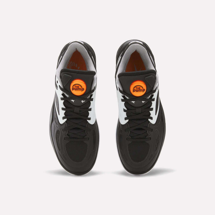 Top view of a pair of Reebok Engine A Pump Shoes in black and white, featuring black laces and a round orange Pump button on each tongue. Showcasing innovative Pump technology, these modern performance basketball shoes are placed side by side on a white background.