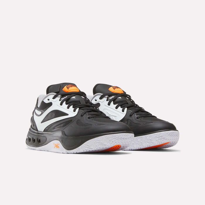 A pair of Reebok Engine A Pump Shoes in black, white, and orange with a chunky sole and curved design lines, featuring Pump technology for enhanced fit and support, displayed against a plain white background.