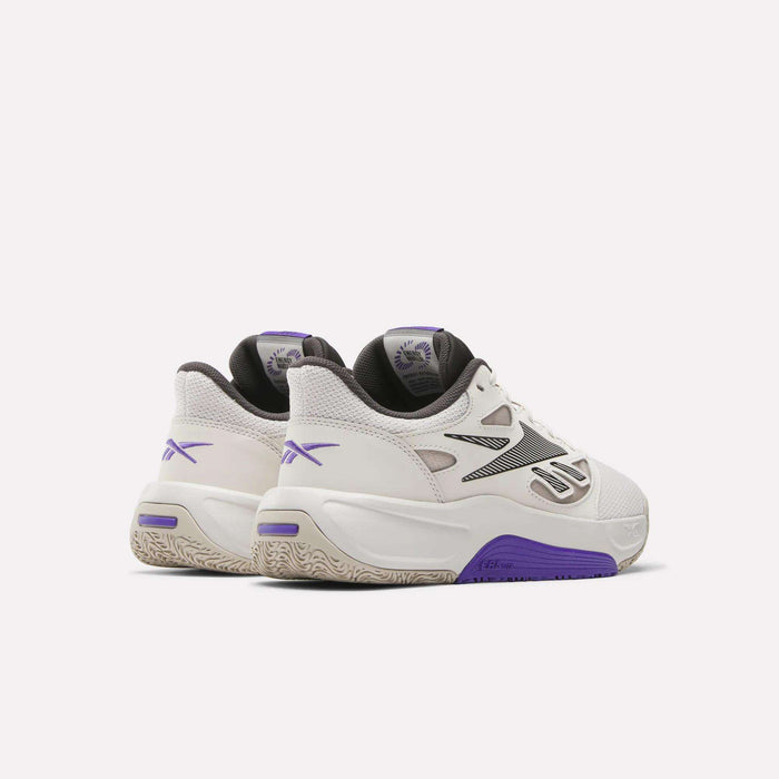 A pair of Reebok Engine LT Shoes in white with purple and black accents are shown from a rear side angle on a light background. These sneakers feature chunky, cushioned soles with textured details and branded heel and tongue.