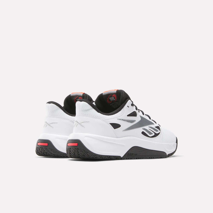 A pair of Reebok Engine LT Shoes in white with black soles, black and silver details, and red accents are positioned side by side on a plain light background, facing away and slightly to the right.