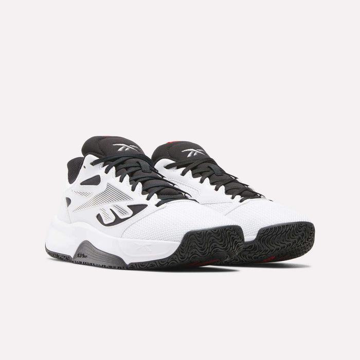 A pair of Reebok Engine LT Shoes in white with black accents and textured black soles, shown on a plain light background. These performance sneakers feature mesh uppers, the iconic logo, and a low-cut design for agility.