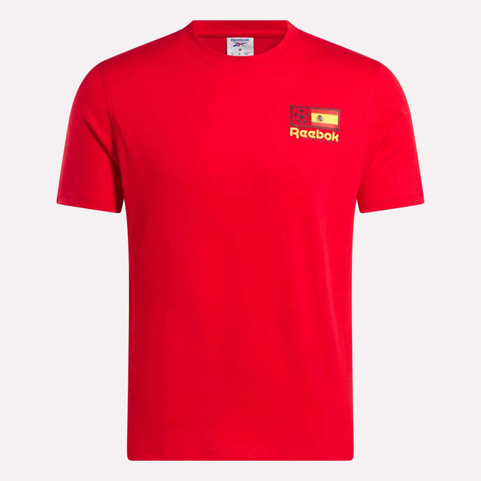 The España Football T-Shirt by Reebok is a plain red cotton tee with a small yellow Reebok logo, lion graphic, and the Spanish flag on the left chest, featuring a classic crew neck and short sleeves.