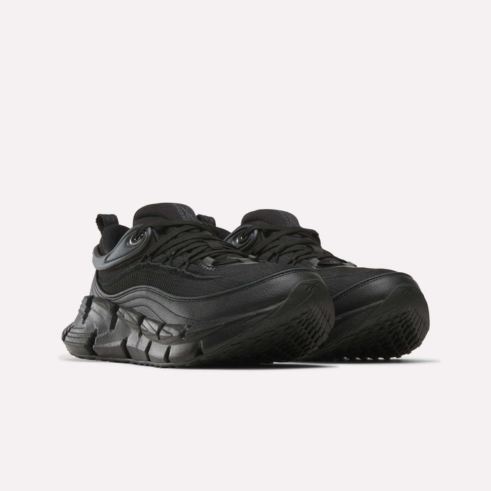 A pair of Reebok Floatzig Encore Running Shoes in an all-black colorway featuring chunky, thick, textured soles and layered detailing, designed for walking and fitness, displayed on a plain white background.