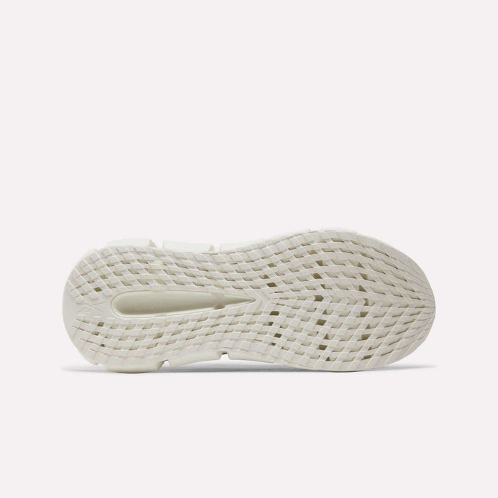 The image displays the outsole of a white Floatzig Encore Running Shoe by Reebok, featuring a textured, grid-like tread pattern designed for traction and photographed against a plain light background—evocative of the innovative sole characteristic of Reebok’s Zig tech collection, making these shoes ideal for walking and fitness.
