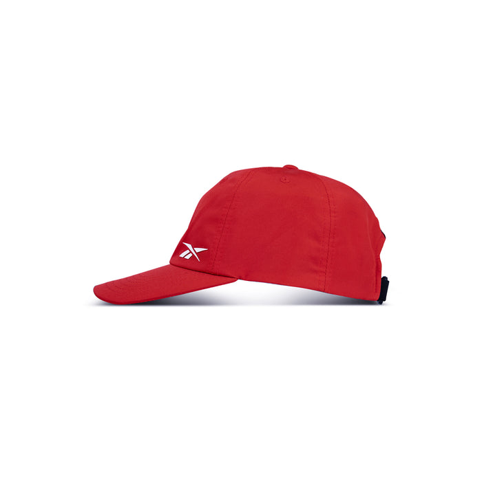 The Reebok Flow Cap in red features a curved brim and a small white Reebok logo on the front left panel, shown in side profile against a plain white background.