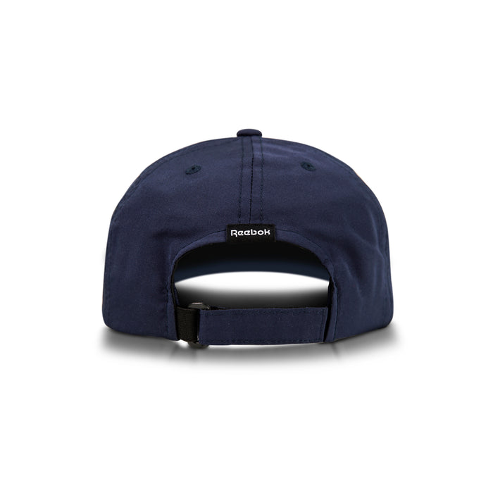 The Reebok Flow Cap in navy blue is shown from the back, highlighting its adjustable strap, a black Reebok logo tag above the opening, and a moisture-wicking sweatband for comfort.