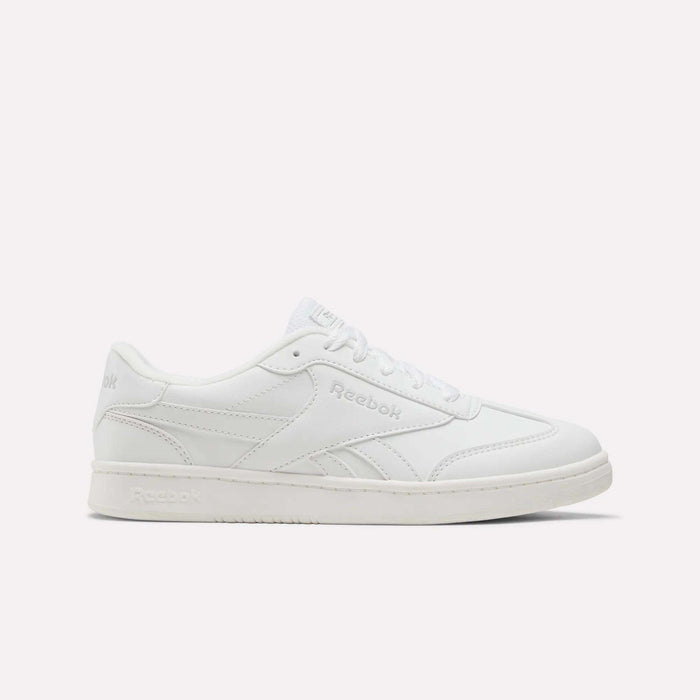 A white Reebok Forte Pitch Shoe for big kids, featuring a low-top silhouette, lace-up closure, and subtle stitched accents is displayed from the side against a plain light backdrop—a contemporary update on court-inspired footwear.