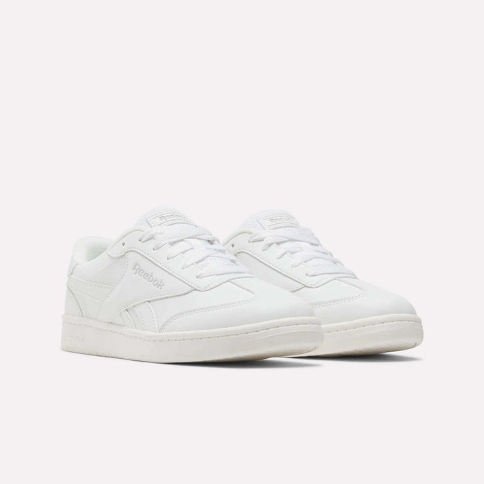 A pair of Reebok Forte Pitch Shoes - Big Kids in classic white, showcasing a court-inspired sneaker design with coordinating white laces and soles, displayed against a plain white background.