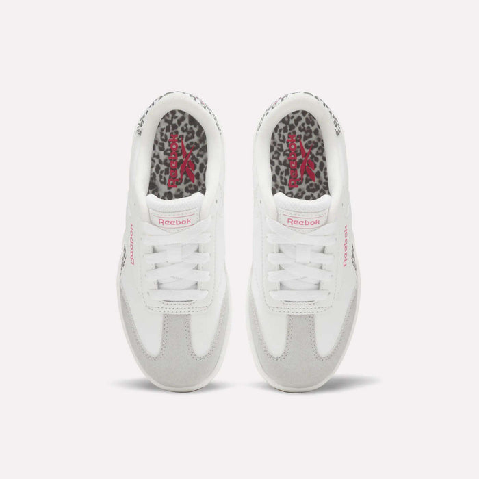 The Forte Pitch Shoes – Big Kids by Reebok, seen from above, feature white uppers with pink Reebok logos and leopard print insoles. The sneakers are placed side by side on a plain light background.