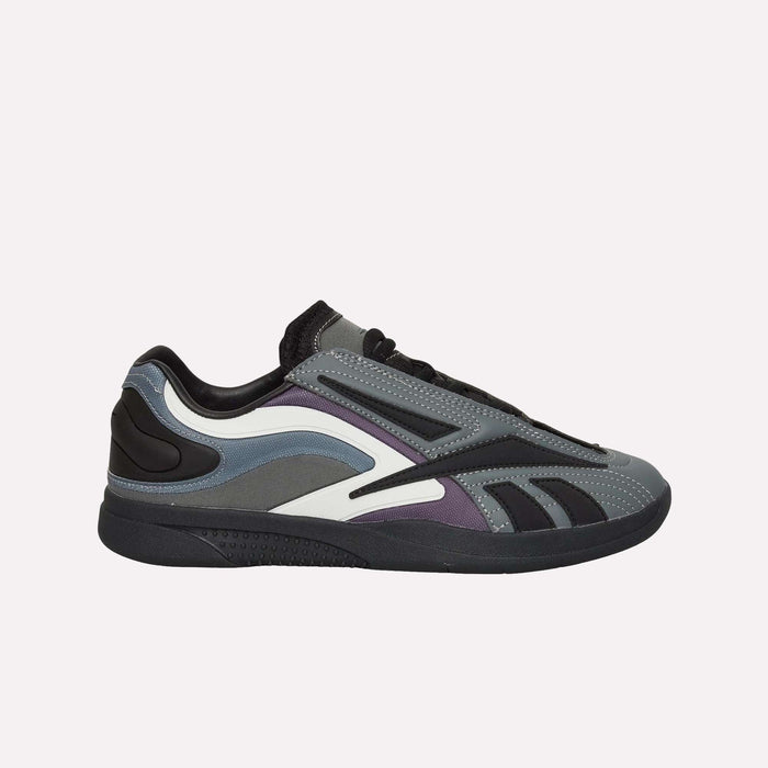 The Reebok Hammer Pro LTD Shoes feature layered faux leather panels in gray, black, and purple, a modern low-top design, black laces, and a chunky black sole—all set against a crisp white background.