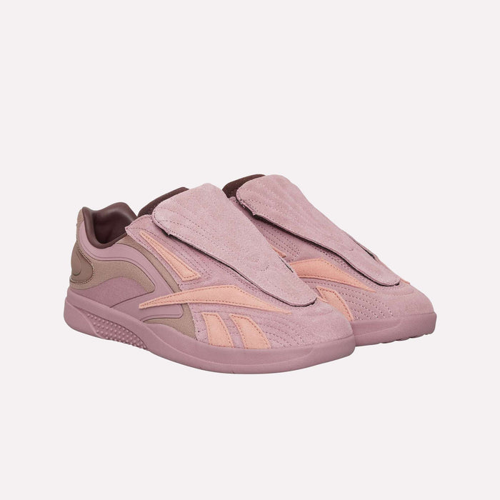 A pair of Reebok Hammer Pro LTD Shoes in pink and mauve, showcasing a suede upper with flap coverings, abstract design accents, and a sturdy rubber sole, displayed on a plain white background.