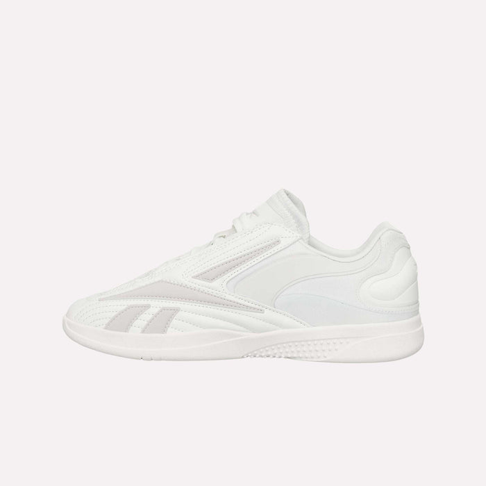 Side view of the Reebok Hammer Pro LTD Shoes, highlighting a white athletic design with subtle gray accents. These shoes feature a faux leather upper, durable rubber sole, lace-up closure, and sleek stitched detailing for a contemporary finish.