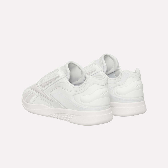 A pair of Reebok Hammer Pro LTD Shoes in white, featuring a subtle pattern and a thick, durable rubber sole, crafted from premium faux leather and arranged at an angle to highlight the heel and side details, set against a plain white background.