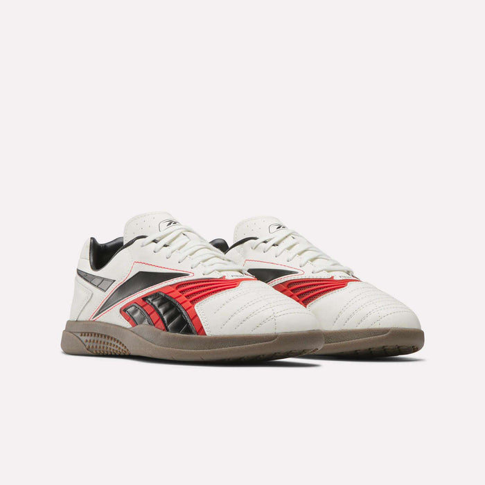A pair of Reebok Hammer Valde Shoes with a white leather upper, red and black accents, and gum-colored soles is displayed against a plain white background.