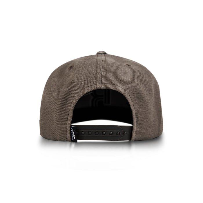 A brown Reebok Identity Drop R Cap is shown from the back on a white background, highlighting its adjustable snapback closure and a small black tag on the left side.
