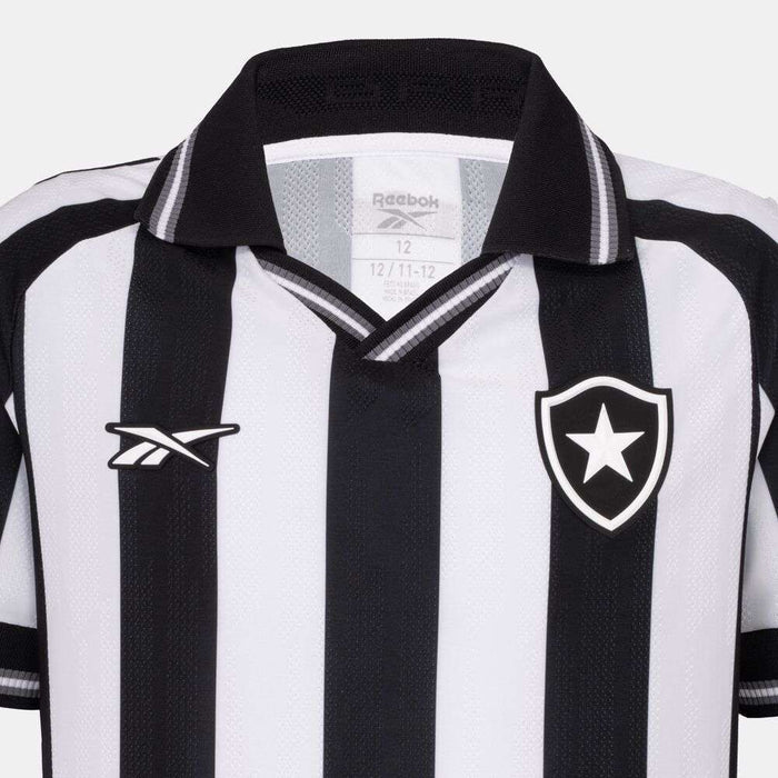 The Kids' Botafogo Youth Home Jersey by Reebok features classic black and white vertical stripes, a black collar, the Reebok logo on the right chest, and a shield with a white star on the left—a timeless 25/26 football shirt.