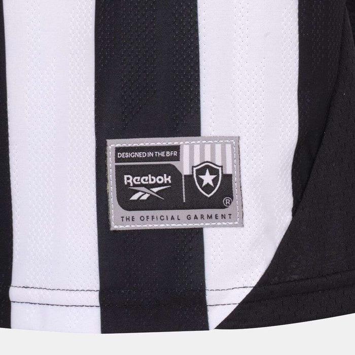 Close-up of a black and white striped Kids' Botafogo Youth Home Jersey by Reebok, featuring a rectangular patch with the star emblem and text: "DESIGNED IN THE BFR" and "THE OFFICIAL GARMENT.