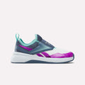 The Kids' Nano Play Slip-on by Reebok is a colorful girls’ training shoe featuring a white sole, teal and navy upper, teal heel loop, and purple accents—shown in side view against a plain white background.