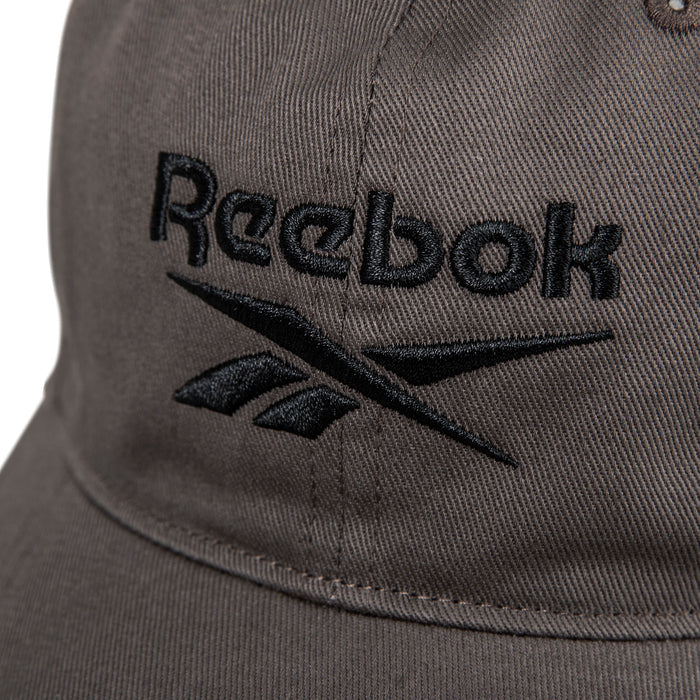 Close-up of the Reebok Logo Cap— a brown fabric baseball cap with the black embroidered Reebok logo and name on the front.