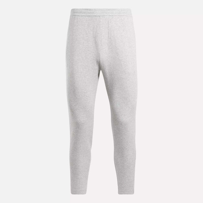 The Reebok Men's Active Collective DreamBlend Pants in light gray feature a slim, tapered leg, soft DreamBlend fabric, and an elastic waistband, shown here on a plain white background.