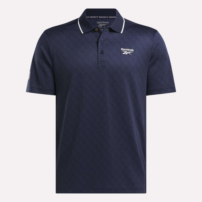 The Men's BDC Signature Polo Shirt by Reebok is navy blue with a subtle pattern, white piping on the collar, and Reebok logos. Made from RBK-DRY fabric, it features a three-button placket and short sleeves for cool comfort.