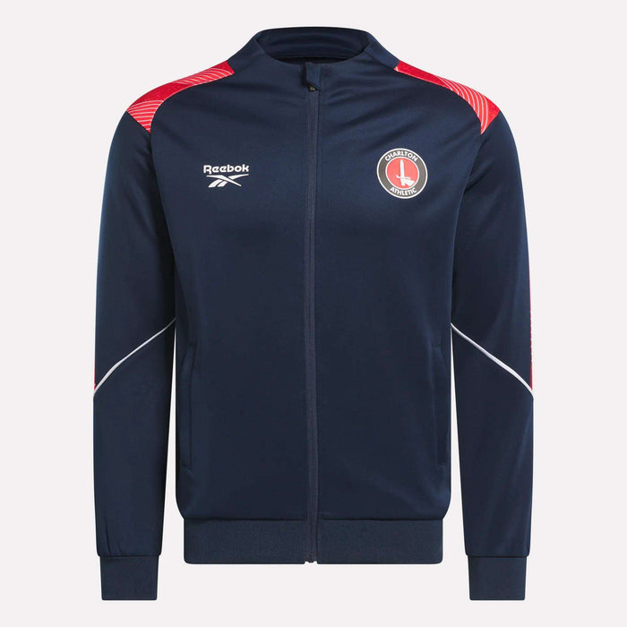The Men's Charlton Training Jacket by Reebok is navy blue with red and white accents, featuring a club jersey print, chest logos, a zip-up front, and ribbed cuffs for comfort.