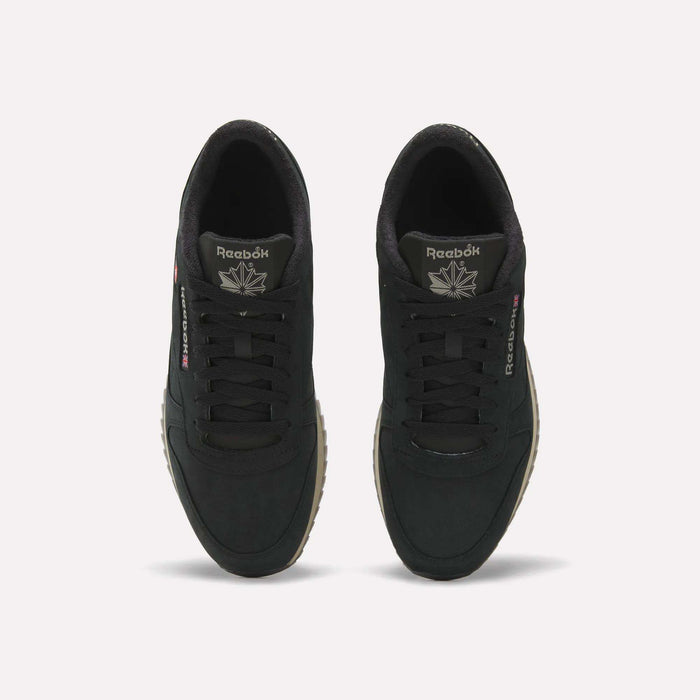 A top view of the Men’s Classic Leather Ripple Shoes by Reebok, featuring black uppers with matching black laces, white Reebok branding on the tongue and side, a comfortable EVA midsole, and tan ripple outsoles, displayed against a plain light background.