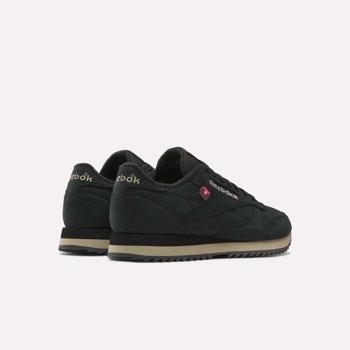 A pair of Reebok Men’s Classic Leather Ripple Shoes in black with beige soles and an EVA midsole are displayed at an angle, facing away from the camera against a plain white background.