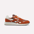 A single Muted Copper, Rust, and Chalk Reebok Men’s Classic Nylon 89 Shoe is shown in side profile on a plain white background, featuring laces, a white sole with an EVA midsole, and suede and mesh details.