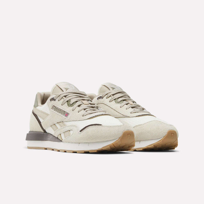 The Reebok Men's Classic Nylon 89 Shoes feature a beige suede upper with mesh panels, brown accents, gum rubber soles, and the signature Reebok logo on the side. Displayed against a plain white background.