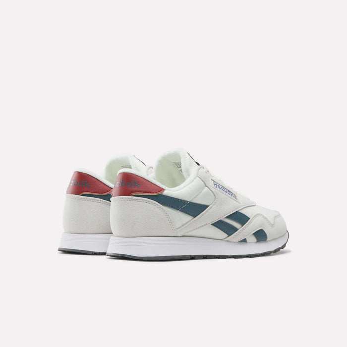 A pair of Men’s Classic Nylon Shoes by Reebok in white, featuring blue stripes and red accents, crafted from mixed materials with an EVA midsole, is displayed from the back and side against a plain light background.
