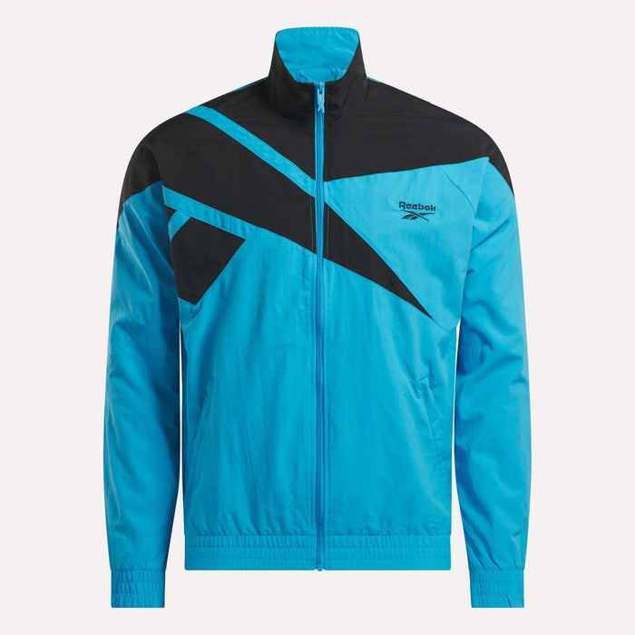 The Reebok Men's Classics Track Top features a blue design with black geometric accents on the chest and shoulders, zip-up front, high collar, elastic cuffs, and a Reebok logo on the left chest for casual comfort.