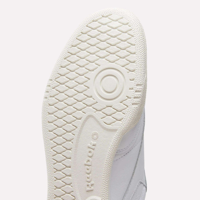 Close-up of the white sole on Reebok Men's Club C 85 Shoes, highlighting the textured diamond-patterned tread and embossed Reebok logo—iconic retro sneakers crafted with premium garment leather.