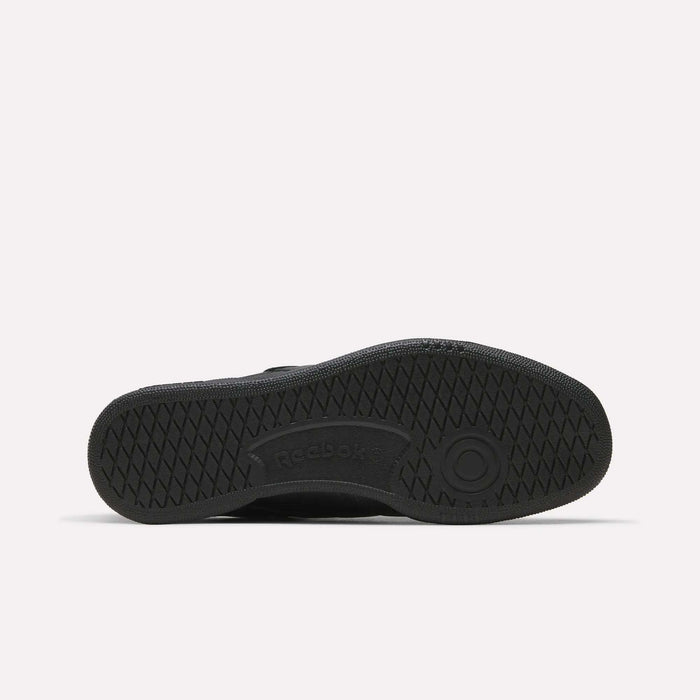 Black Reebok Men’s Club C 85 Shoe shown from the bottom, highlighting its textured rubber sole with a circular pattern and the Reebok logo at the center. Made from premium garment leather, this retro sneaker stands out against a plain white background.