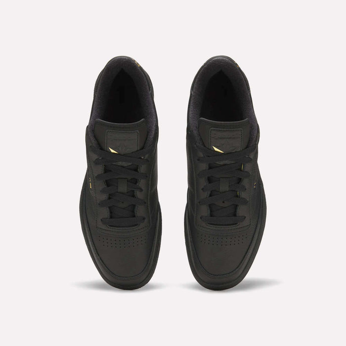 A pair of Reebok Men’s Club C 85 Shoes viewed from above, featuring black laces and subtle gold accents on the sides and tongue, crafted from premium garment leather reminiscent of classic Reebok retro styles, set against a plain white background.