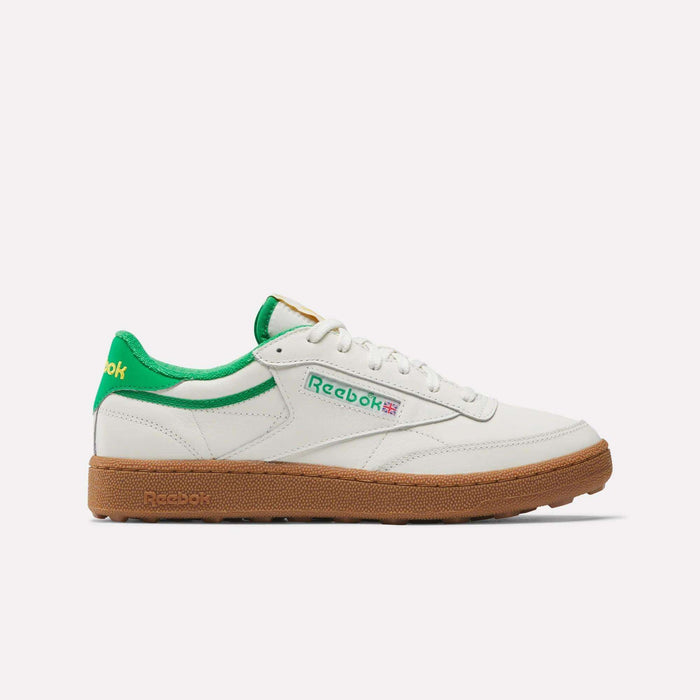 The Reebok Men's Club C Golf Shoes are white low-tops with green accents, a brown gum spikeless outsole, water-resistant leather, and feature green and red Reebok logos. White laces add comfort and style for on or off the course.
