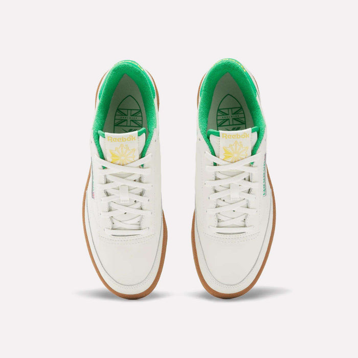 The Reebok Men's Club C Golf Shoes feature a white, water-resistant leather upper, green inner lining, white laces, gum soles, spikeless outsole, and yellow-green tongue branding—shown from above on a plain background.
