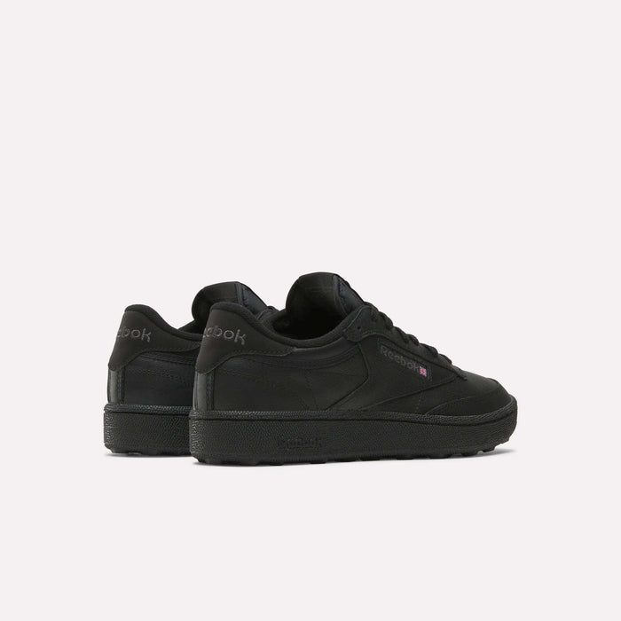 The Reebok Men's Club C Golf Shoes in black feature a low-top, spikeless design. Displayed from the back and side on a white background, the Reebok logo appears on both the heel and side.
