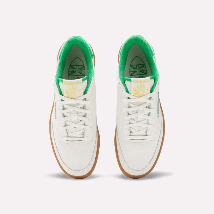 The Reebok Men's Club C Golf Shoes feature a white, water-resistant leather upper, green inner lining, white laces, gum soles, spikeless outsole, and yellow-green tongue branding—shown from above on a plain background.