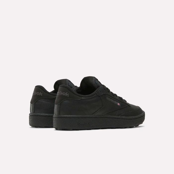 The Reebok Men's Club C Golf Shoes in black feature a low-top, spikeless design. Displayed from the back and side on a white background, the Reebok logo appears on both the heel and side.