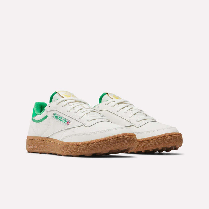 Men's Club C Golf Shoes by Reebok in white with green accents, a gum rubber spikeless outsole, and the Reebok logo on the side, shown against a plain white background.