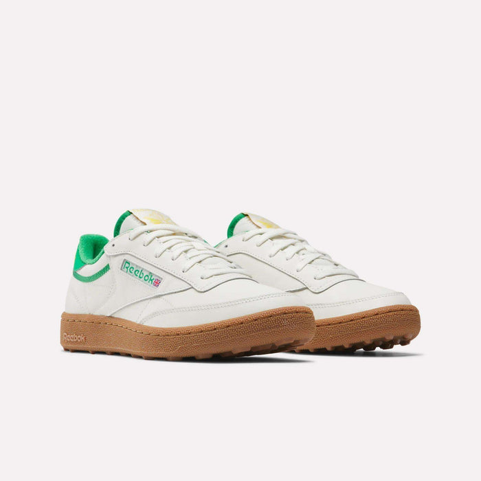 Men's Club C Golf Shoes by Reebok in white with green accents, a gum rubber spikeless outsole, and the Reebok logo on the side, shown against a plain white background.