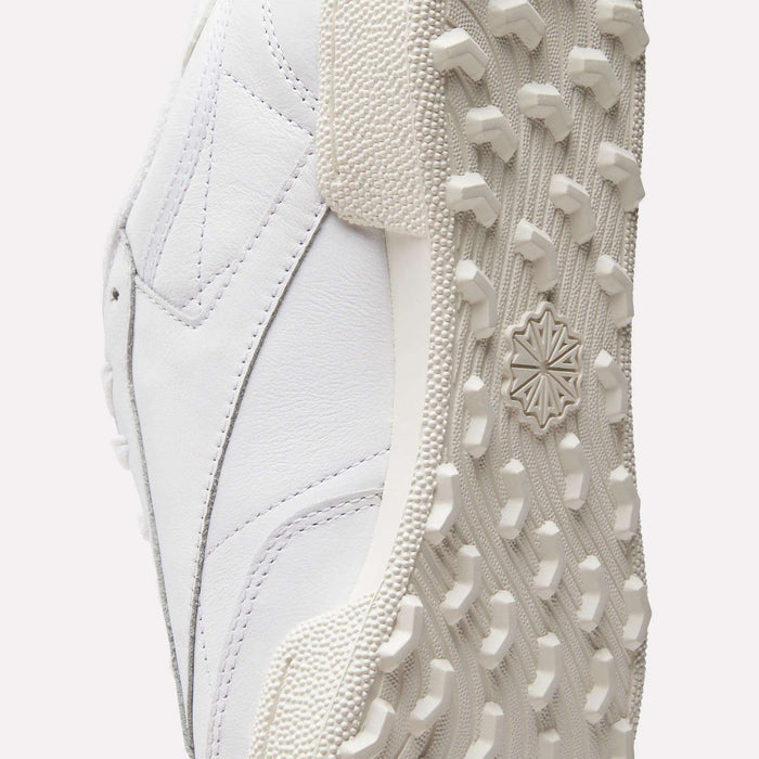 Close-up of the Reebok Men's Club C Golf Shoes shows a spikeless outsole with detailed tread and textured rubber, plus stitching and paneling on the water-resistant leather upper.