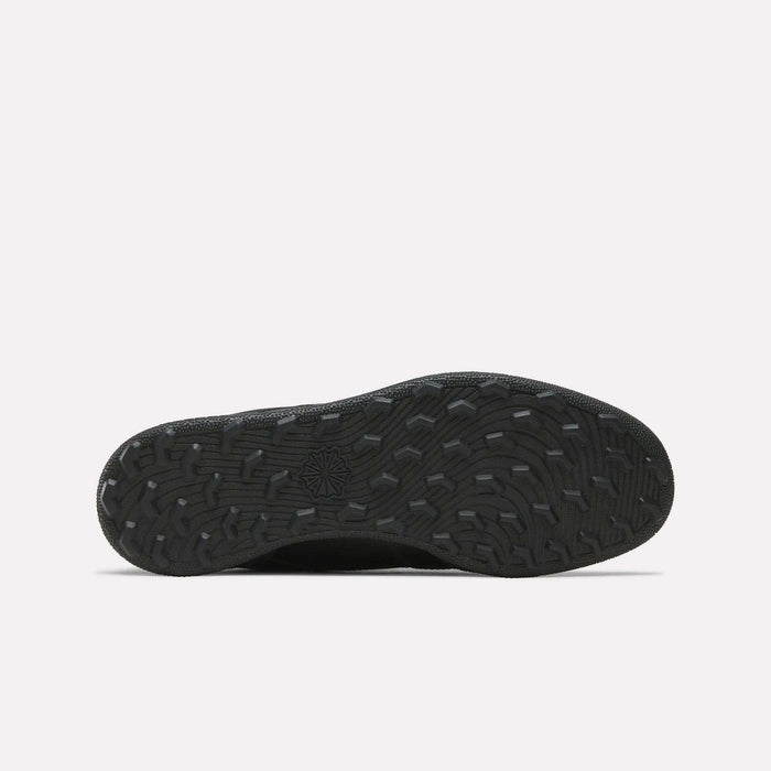 The Reebok Men's Club C Golf Shoes feature a black rubber spikeless outsole with textured, wavy treads and a central star design, ideal for golf, displayed on a plain white background.