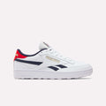 The Reebok Men's Club C Revenge Golf Shoes feature a white design with navy and red accents, gold branding, a red logo heel tab, and spikeless outsole for comfort on or off the golf course.