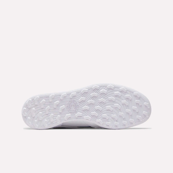 The image shows the white, textured sole of the Reebok Men's Club C Revenge Golf Shoes from below, with various grip patterns and a star-shaped design—highlighting its spikeless outsole for versatile traction.