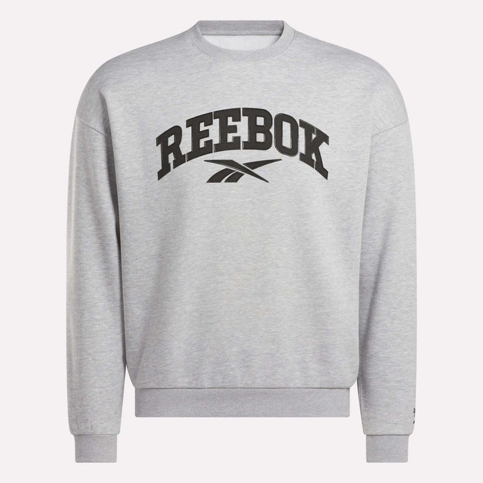 The Reebok Men's Cottle Sweatshirt is light grey with a black Reebok logo and brand name on the chest. This crewneck features long sleeves, ribbed cuffs and hem, and provides a relaxed, casual fit.
