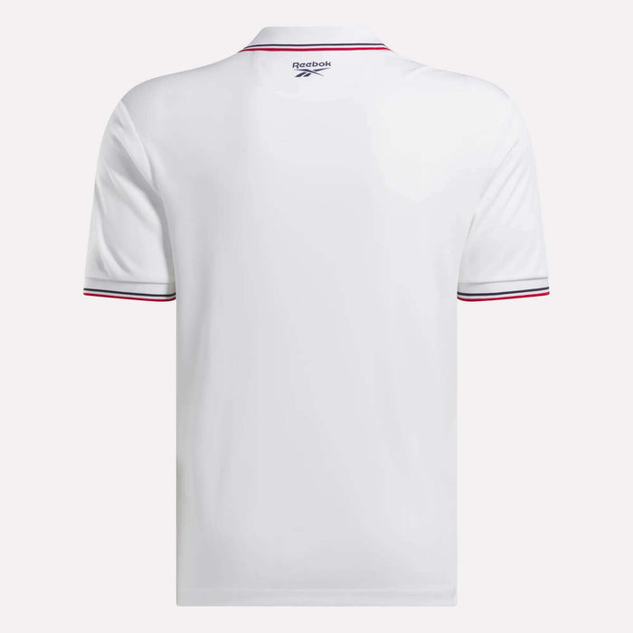 The Reebok Men's Country Club Oxford Pique Polo Shirt in white is shown from the back, featuring thin red and black stripes on the sleeve cuffs and a small Reebok logo near the collar for a stylish, sporty accent.