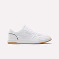 The Reebok Men’s Court LXS Shoes in White/Legacyblue/Grey1 feature a premium full grain leather construction, low-top silhouette, lace-up closure, perforated side detailing, and a light brown rubber sole. Displayed in side profile against a plain light background, these men’s court shoes by Reebok offer an effortless blend of style and comfort.